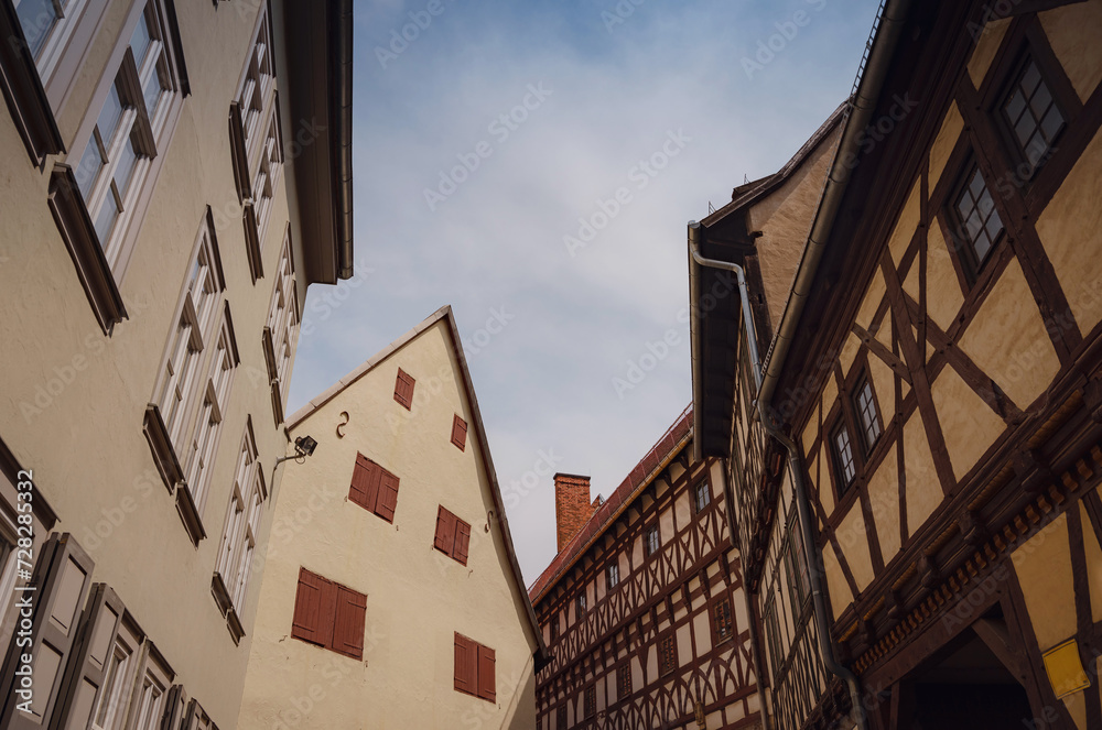 Obraz premium spring trip to Europe. Travel and German sightseeing locations. scenic view to facade of old historic houses somewhere in Erfurt city, Traditional half-timbered houses makes cozy and fairy tail mood