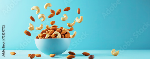 Nut mix almonds and cashews in a bowl flying through the air.