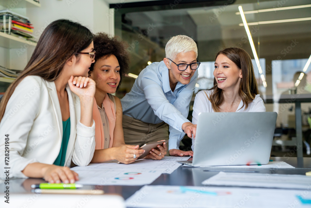 Smiling diverse colleagues gather in boardroom brainstorm discuss financial statistics together