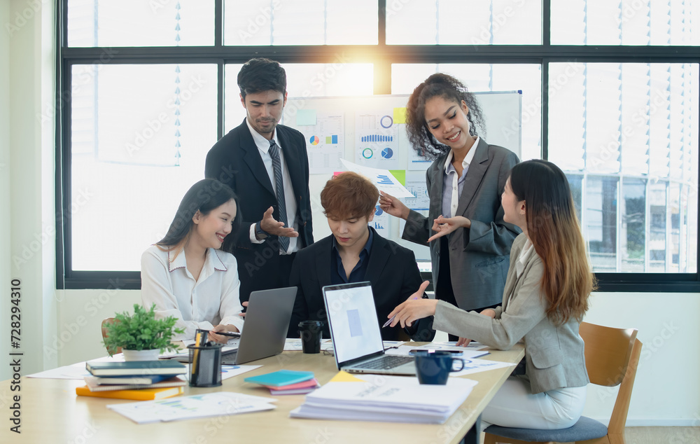 Team of asian business working with document paper sitting at desk in office in meeting room, Business team working with project statistics, Asian business team and present graphic info in room. Team of asian business working with document paper sitting at desk in office in meeting room, Business team working with project statistics, Asian business team and present graphic info in room.