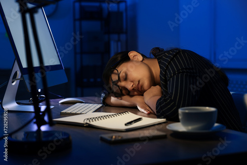 Tired overworked businesswoman napping at night in office