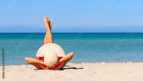 Fototapeta Naklejka Na Ścianę i Meble -  A slender girl on the beach in a straw hat in the colors of the Poland flag. The concept of a perfect vacation in a resort in the Poland. Focus on the hat.