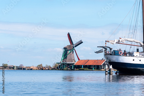 Welcome to Holland above a river and the windmills of Zaanse Schans, the Netherlands with its traditional houses, windmills, warehouses and workshops. © Sylvain