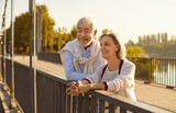 Senior couple embraces the simple pleasures of life, taking a active walk through the city park. Their smiles radiate happiness, capturing the essence of an active and enjoyable vacation or holiday.
