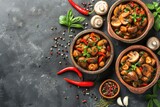 Fresh delicious spicy canned mushrooms with spices and herbs in ceramic dishes on a dark concrete background 