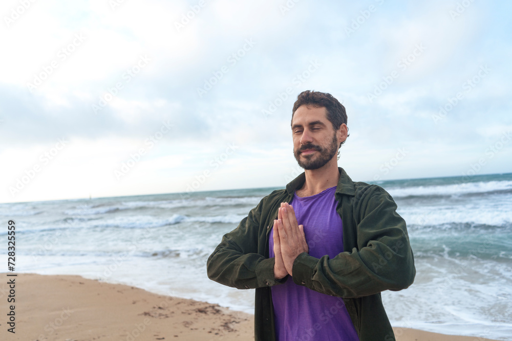Smiling man standing with hands clasped in front of sea Smiling man standing with hands clasped in front of sea