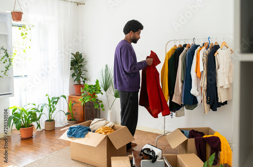Man decluttering clothes for recycling at home photo