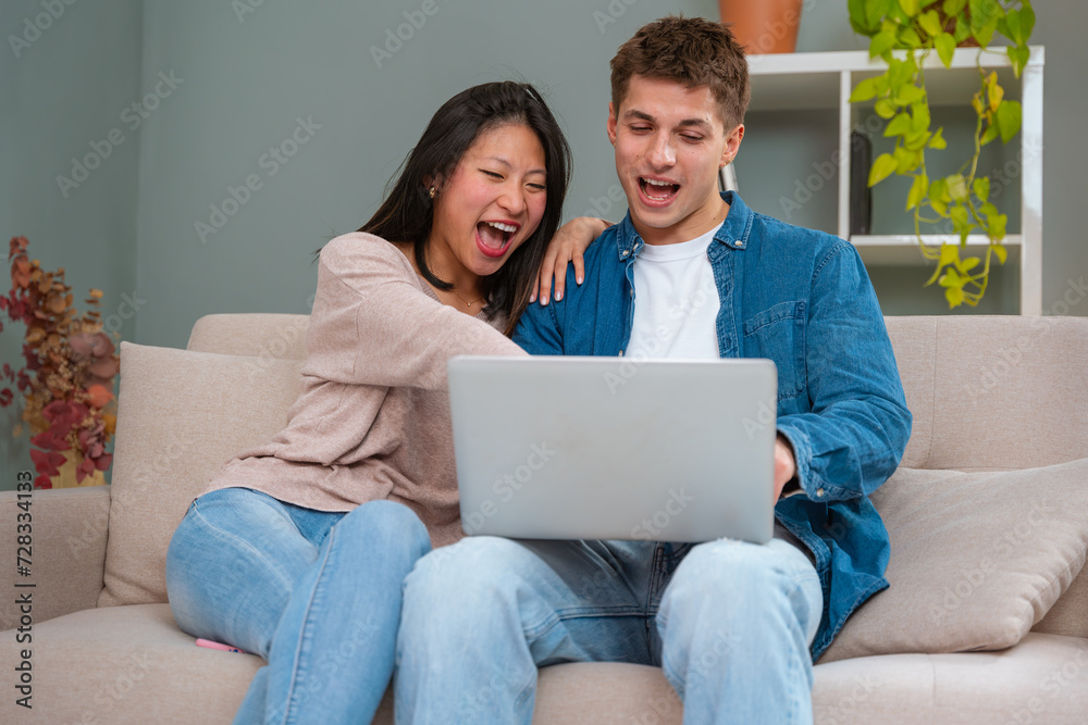 Happy multiethnic man and woman have fun browsing internet on laptop. Technology concept. Happy multiethnic man and woman have fun browsing internet on laptop. Technology concept.