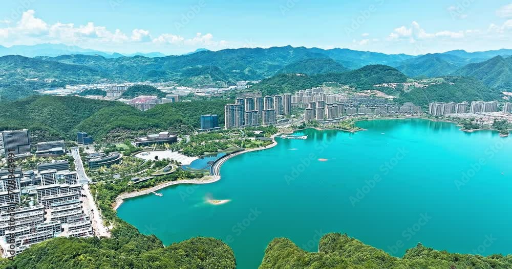 Aerial video of clear lake water and mountain with residential area buildings landscape in Hangzhou. Drone shooting forward. Aerial video of clear lake water and mountain with residential area buildings landscape in Hangzhou. Drone shooting forward.