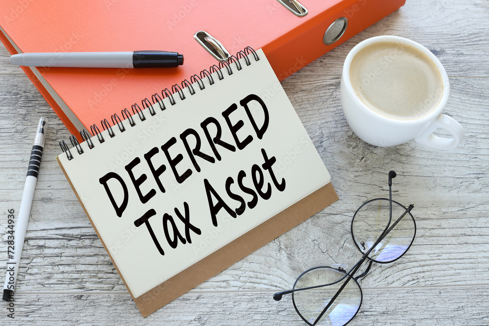 orange folder and cup of coffee. text Deferred tax asset orange folder and cup of coffee. text Deferred tax asset