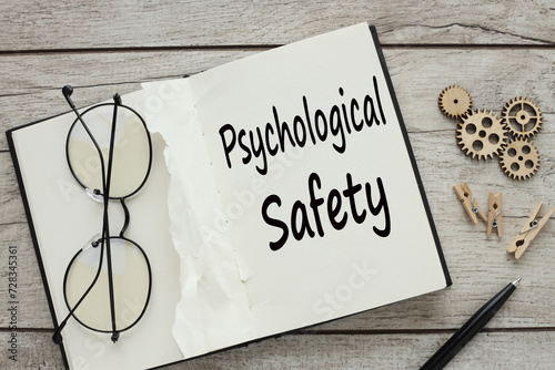 glasses on an open notepad. text on page PSYCHOLOGICAL SAFETY -