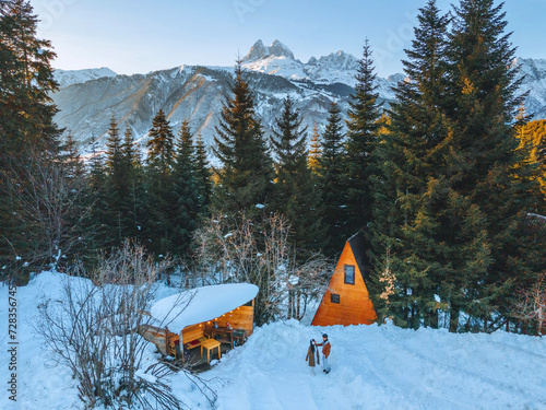 A triangular house in the middle of a snow-covered forest in winter in Georgia. photo