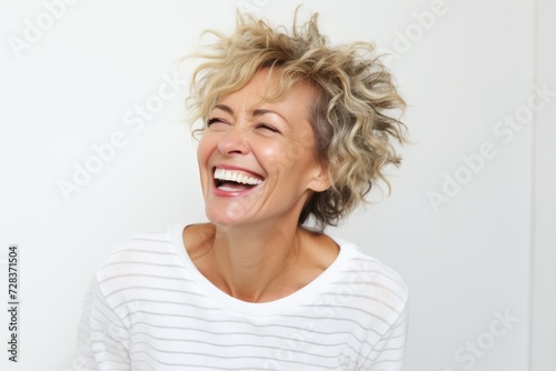 Happy middle-aged woman laughing and looking up on white background