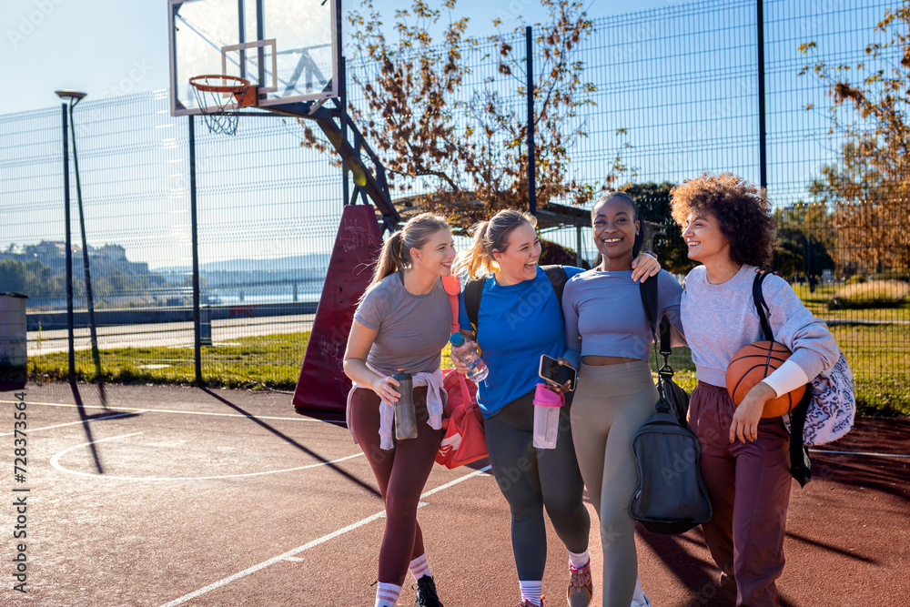 Fototapeta premium Diverse group of young woman walking on basketball court preparing to play.