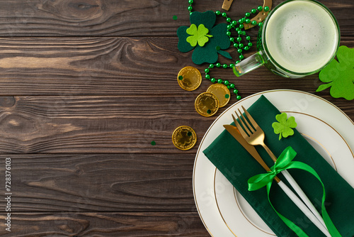 Revel in St. Patric's Day spirit at the pub scene. Top view snapshot of a table adorned with plate, utensils, beer glass, leprechaun's gold, lucky horseshoe, trefoils, and beads on wooden surface