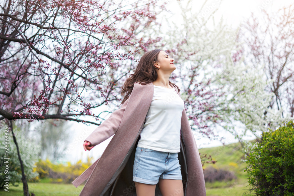 Healthy happy woman on spring outdoors. Smiling young woman on the spring garden enjoy blooming flowers of tree. Harmony and enjoy nature. No allergy. Healthy happy woman on spring outdoors. Smiling young woman on the spring garden enjoy blooming flowers of tree. Harmony and enjoy nature. No allergy.