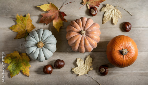 Pumpkins, maple leaves and chestnuts on a wooden table, thanksgiving concept