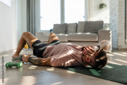 Man resting after home workout, New Year's resolutions, exercising as healthy lifestyle and selfcare. Concept of morning or evening workout routine.