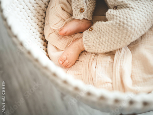 Feet of a newborn baby in a cradle, top view, space for text photo