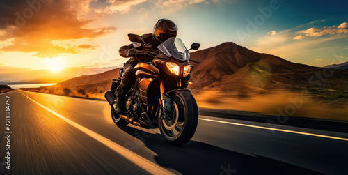 A motorcyclist rides on a highway towards the sunset  with the dynamic landscape blurring past.