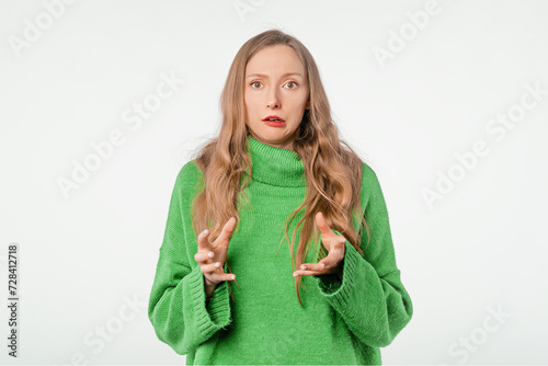 Portrait of shocked young woman expressing worry, wearing soft green sweater, standing over white background