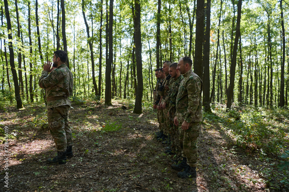 A dedicated group of soldiers engages in Islamic prayer amidst the challenging and perilous conditions of a military operation in dense forested areas