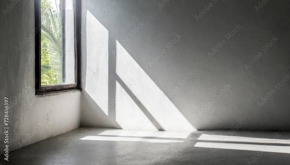 Obraz premium shadow on white concrete wall in the room from window with morning light