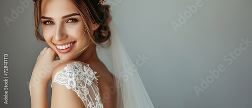wedding advertising bride standing . she is wearing a beautiful dress and she is smiling. on a gray background  with empty copy space