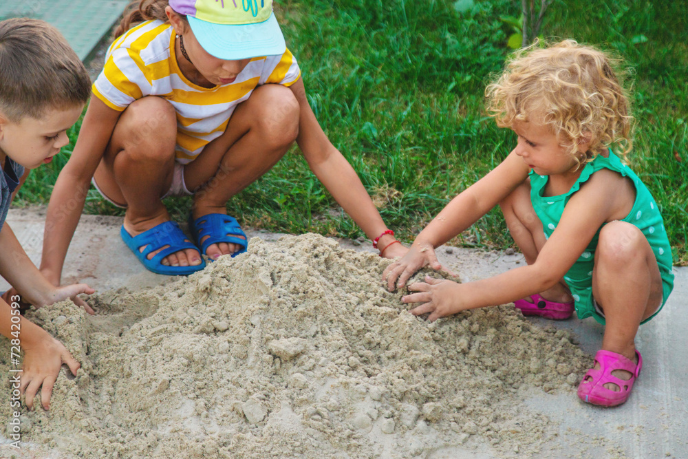 Children play with sand on the street. Selective focus. Children play with sand on the street. Selective focus.