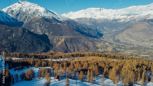 Aerial view of winter landscape with mountain peaks covered with snow and coniferous forest. Natural background.