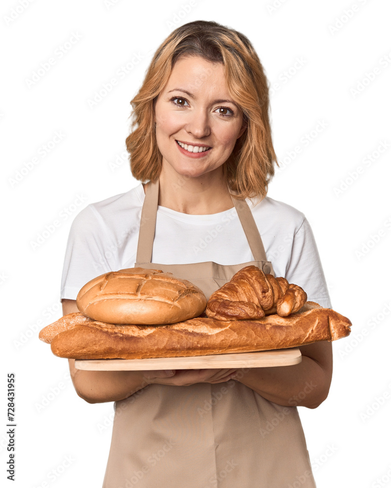 Middle-aged Caucasian woman baker with bread tray laughing and having fun. Middle-aged Caucasian woman baker with bread tray laughing and having fun.