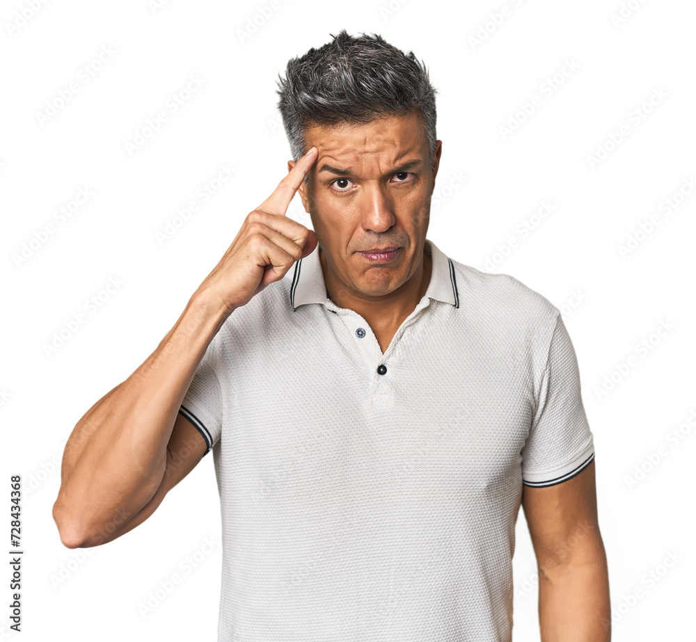 Middle-aged Latino man pointing temple with finger, thinking, focused on a task. Middle-aged Latino man pointing temple with finger, thinking, focused on a task.