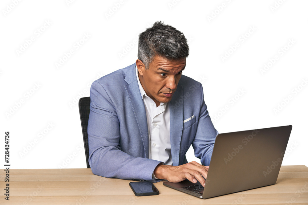 Middle-aged Hispanic man working on laptop in business suit Middle-aged Hispanic man working on laptop in business suit