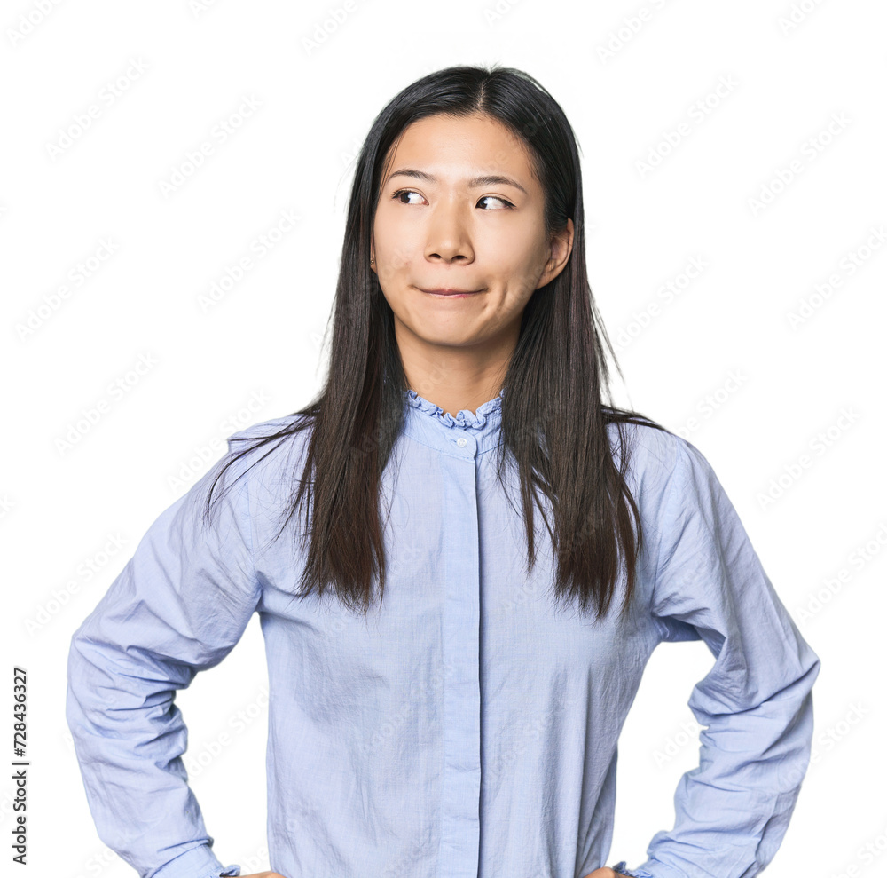 Young Chinese woman in blue shirt confused, feels doubtful and unsure. Young Chinese woman in blue shirt confused, feels doubtful and unsure.
