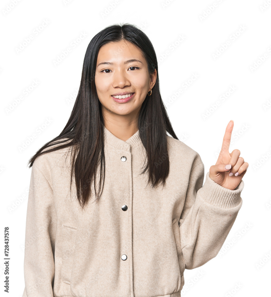 Young Chinese woman in studio setting showing number one with finger. Young Chinese woman in studio setting showing number one with finger.
