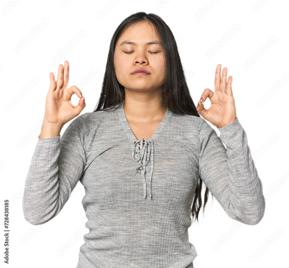 Young chinese woman isolated relaxes after hard working day, she is performing yoga. Young chinese woman isolated relaxes after hard working day, she is performing yoga.