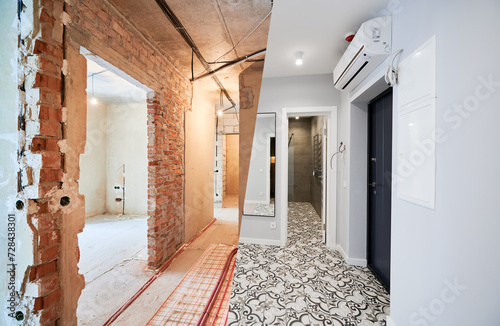 Old apartment with brick walls and new renovated flat with doors, mirror, air conditioner and stylish design in white tones. Inferior of apartment before and after renovation. photo