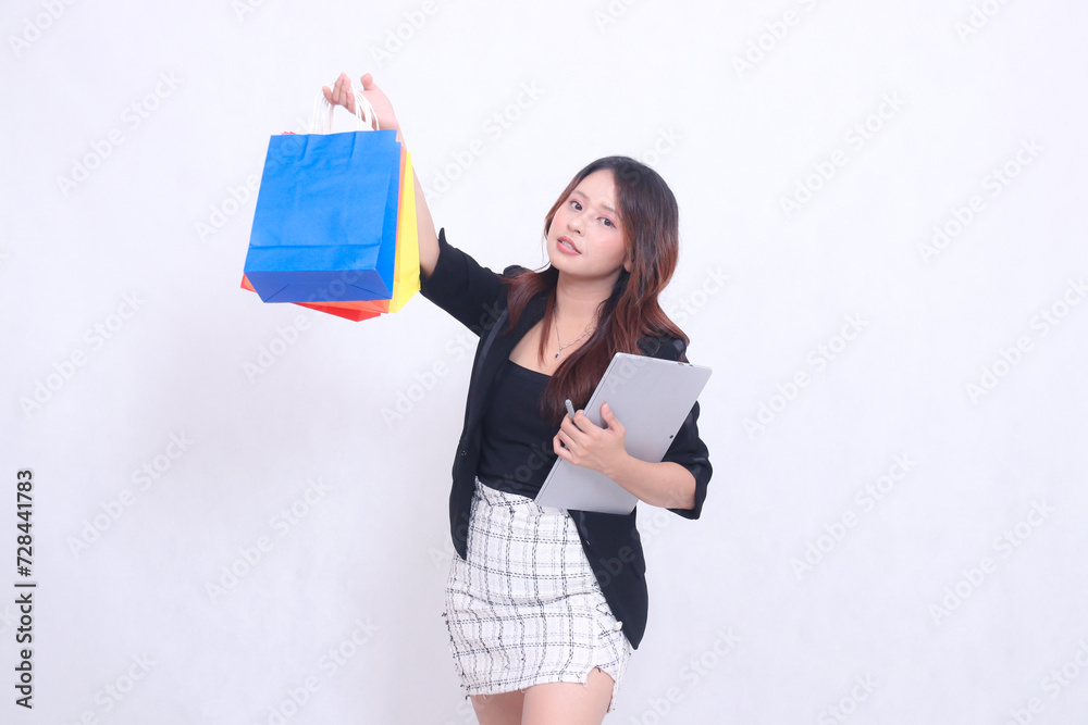 young beautiful woman customer 20s formal office flat smile tilted hold pen tablet and carry shopping paper bag up high isolated white background young beautiful woman customer 20s formal office flat smile tilted hold pen tablet and carry shopping paper bag up high isolated white background