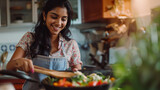 Portrait of a joyful Indian woman, savoring the aroma, and smiling while cooking in her kitchen