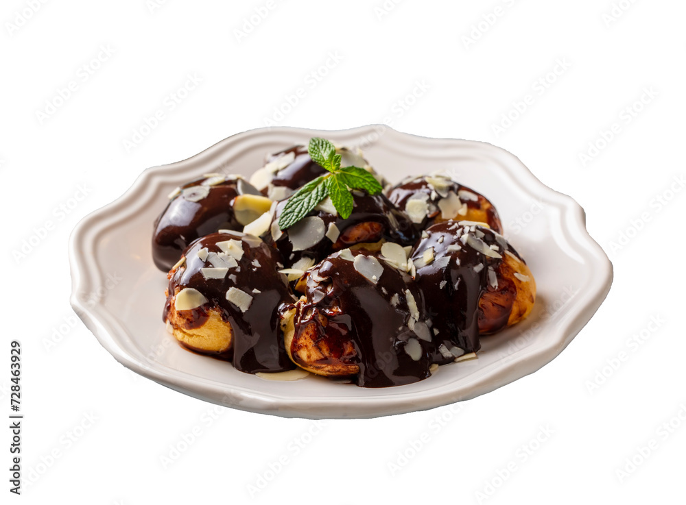 Delicious profiteroles with chocolate and white plate. Selective focus image on light background.