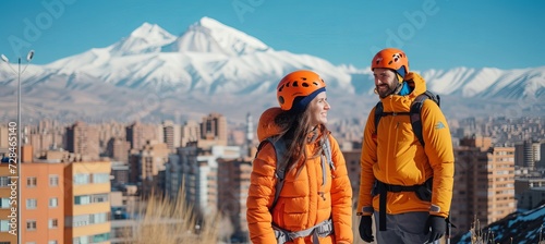Happy smiling couple hiking in mountains with city and mountain view, copy space for text placement