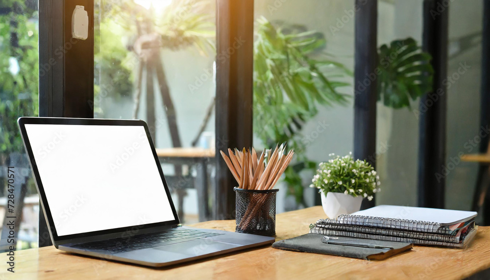 Close-up view of open blank screen laptop computer with office supplies in modern office Close-up view of open blank screen laptop computer with office supplies in modern office
