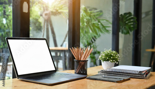 Close-up view of open blank screen laptop computer with office supplies in modern office