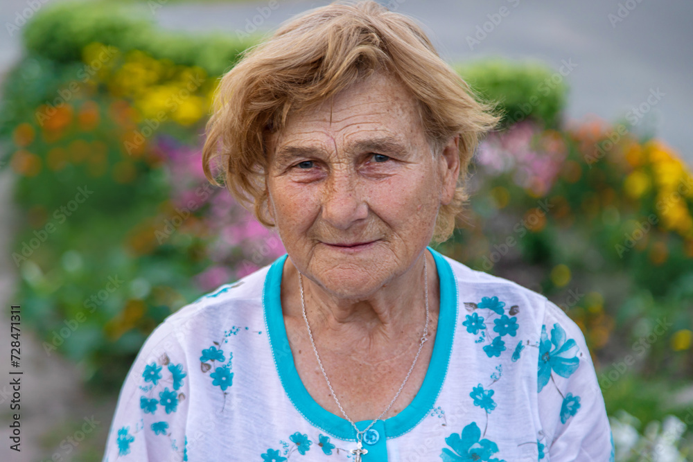 Old woman in the garden. Selective focus. Old woman in the garden. Selective focus.