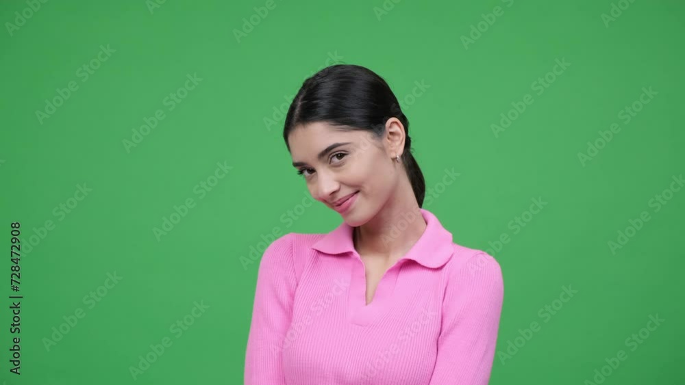 Bashful, shy Caucasian young charming woman portrait, smiling and looking at camera, playfully flirting standing on green background. Bashful, shy Caucasian young charming woman portrait, smiling and looking at camera, playfully flirting standing on green background.