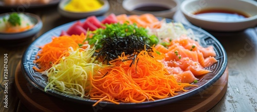 Yusheng is a dish made of raw salmon, shredded veggies, and sauces. photo