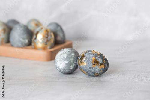 Stylish grey Easter eggs made of marble and concrete with a golden potala on a grey background. Coloring eggs with natural dye karkade tea. . The concept of a happy Easter.