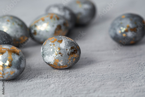 Stylish grey Easter eggs made of marble and concrete with a golden potala on a grey background. Coloring eggs with natural dye karkade tea. . The concept of a happy Easter.