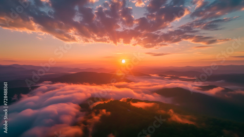 Aerial view of a breathtaking sunset over mountains, with clouds and warm skies, from a pilot's perspective.