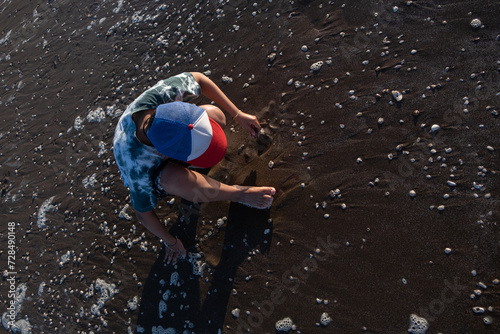 Fototapeta Naklejka Na Ścianę i Meble -  Chico recolectando conchas en la playa